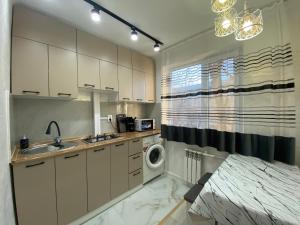 a kitchen with a sink and a washing machine at Люксовая квартира in Taraz