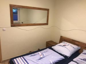 a bedroom with two beds and a mirror at Kompassrose in Prerow
