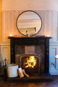 a fireplace with a mirror on top of it at Royal Oak at Keswick in Keswick
