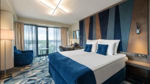 Un pat sau paturi într-o cameră la Wellton Riverside SPA Hotel