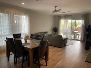 a living room with a table and a couch at Modern Four Bedroom Holiday Home Available in Deebing Heights in Loamside