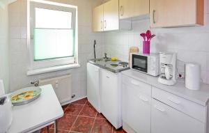 a kitchen with white cabinets and a microwave at Ferienwohnung Mirow Ot Qualzow in Qualzow