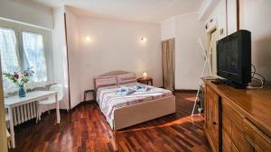 a bedroom with a bed and a flat screen tv at La voce del porto in Ancona
