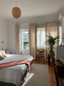 a bedroom with a bed and a tv and a window at MAR VERDE - Parede-Cascais in Parede