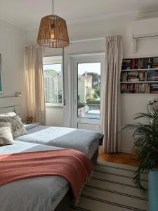 a bedroom with a bed and a large window at MAR VERDE - Parede-Cascais in Parede