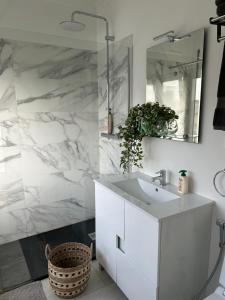 a white bathroom with a sink and a mirror at MAR VERDE - Parede-Cascais in Parede