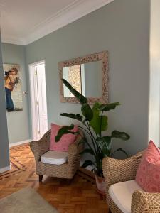 a living room with two chairs and a mirror at MAR VERDE - Parede-Cascais in Parede
