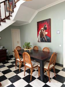 a dining room with a black table and chairs at MAR VERDE - Parede-Cascais in Parede