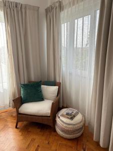 a chair with pillows sitting in front of a window at MAR VERDE - Parede-Cascais in Parede