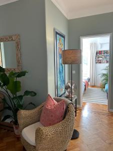 a living room with a wicker chair with pillows at MAR VERDE - Parede-Cascais in Parede