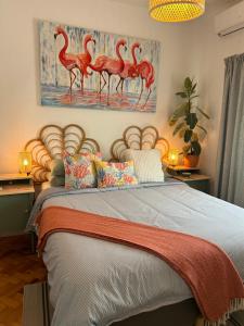 a bedroom with a bed with a painting of flamingos at MAR VERDE - Parede-Cascais in Parede