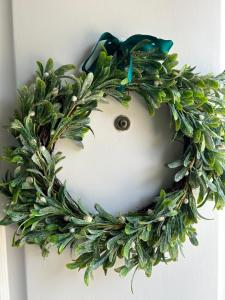 a green wreath is hanging on a door at MAR VERDE - Parede-Cascais in Parede