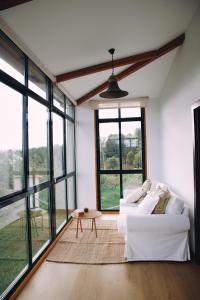a living room with a white couch and large windows at Casa As Nogueiras in Deade +23 photos