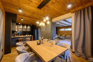 une salle à manger avec une table et des chaises en bois dans l'établissement Three Bedroom Luxury Villa, à Neofit Rilski