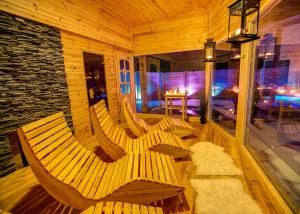 two wooden benches in a room with a table at Greta Resort in Žiar