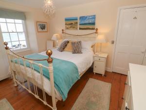 een slaapkamer met een bed met een wit bedframe bij April Cottage in Falmouth