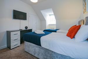 a bedroom with two beds and a television in it at 3 Bedroom Contractor House By Your Lettings Short Lets & Serviced Accommodation Peterborough With Free WiFi and Parking in Peterborough