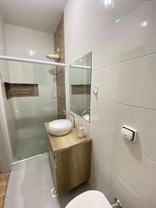 a bathroom with a toilet and a sink and a mirror at Santorini House in Guarujá +35 photos