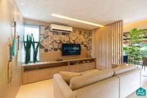 a living room with a couch and a tv at Ykutiba Imbassaí - Apartamento Superior - I103 in Imbassai