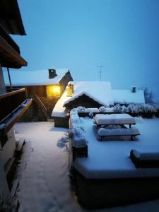 a group of benches covered in snow on a building at La Maison del Bon Grato in Champorcher