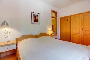 een slaapkamer met een bed en een lamp op een tafel bij Apartments Eli in Mali Lošinj +36 foto's