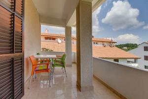 un balcón con mesa y sillas. en Apartments Eli, en Mali Lošinj