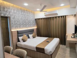 a hotel room with a bed and a desk at Grand Silver in Chennai