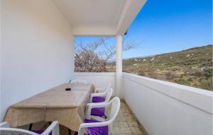 a small balcony with a wooden table and white chairs at Apartment Nedo in Supetarska Draga