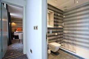 a bathroom with a toilet and a glass door at The Saltoun Inn in Fraserburgh +37 photos