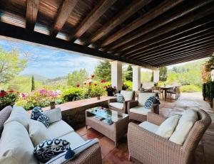an outdoor patio with couches and tables and flowers at Villa Ses Casetes Ibiza in Montecristo