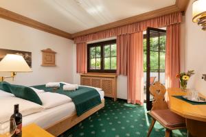 a hotel room with a bed and a desk at Landhaus St. Georg in Gröbming +75 photos