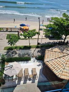 - Vistas a una playa con sillas y sombrillas en Cobertura frente mar 2 suítes, en Itapema