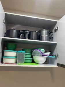 a cabinet filled with dishes and pots and pans at Apartamento Santa Cruz do Capibaribe 3 in Santa Cruz do Capibaribe