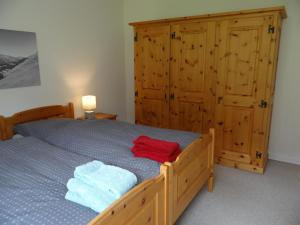 a bedroom with a wooden bed with towels on it at Apartment Erlenrain Wohnung 722E by Interhome in Engelberg +11 photos