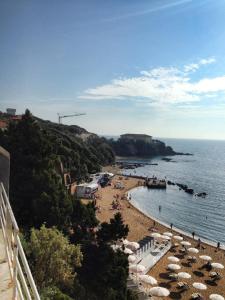 una playa con sombrillas y gente en el agua en Appartamenti Torre Medicea, en Castiglioncello