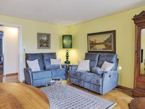a living room with two blue chairs and a table at Apartment Bieri-Haus by Interhome in Unterseen
