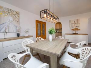 jadalnia z drewnianym stołem i białymi krzesłami w obiekcie Holiday Home Marie Louise by Interhome w mieście Calpe