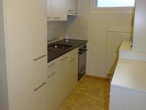 エンゲルベルクにあるApartment Parkweg 9-602 by Interhomeの白いキャビネット、シンク、窓付きのキッチン +1枚の写真