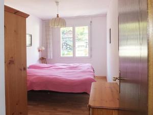 エンゲルベルクにあるApartment Dorfstrasse 53a - 2 by Interhomeのベッドルーム1室(ピンクベッド1台、窓付)