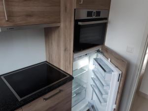 a small kitchen with an open refrigerator at Apartment Casa Selva Hauggaard by Interhome in Valbella +10 photos