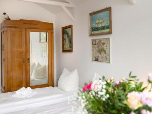 1 dormitorio con 1 cama, espejo y flores en Apartment Luise von Preußen - App-204 by Interhome, en Zinnowitz