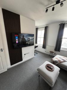 a living room with a flat screen tv on a wall at Central Chic 3 bed, Great Location in Winchester
