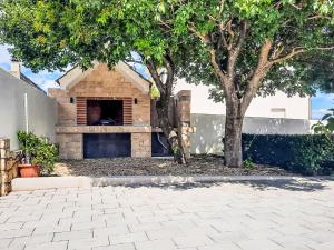 a building with a fireplace in front of a tree at Holiday Home Karlo by Interhome in Posedarje