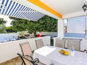 a dining room with a table and chairs and a patio at Holiday Home Karlo by Interhome in Posedarje