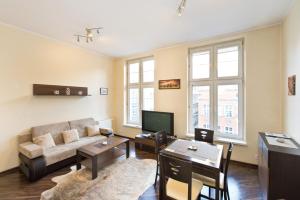 sala de estar con sofá y mesa en Gdańskie Apartamenty - Apartamenty - Długa z Widokiem Na Ratusz i nad Motławą, en Gdansk