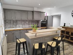 a kitchen with gray cabinets and bar stools at chez sandrou in Aigues-Mortes