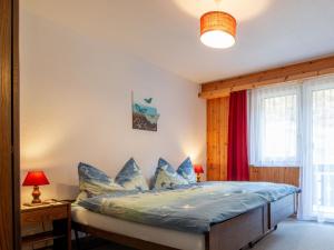 une chambre avec un lit avec des oreillers bleus dans l'établissement Apartment Haus Azur by Interhome, à Saas-Almagell