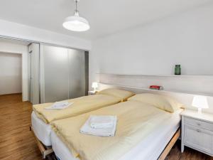 a bedroom with a large bed with two towels on it at Apartment BeKb-Gebäude Apt- 01 by Interhome in Wengen