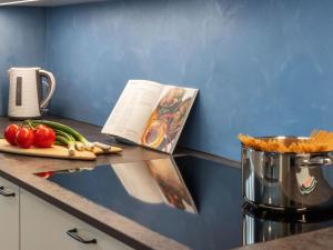 a cook book on a counter with vegetables on it at Apartment BeKb-Gebäude Apt- 01 by Interhome in Wengen