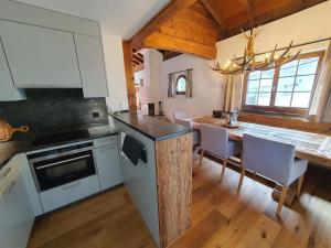 a kitchen with white cabinets and a table with chairs at Apartment Ferienwohnung Selina by Interhome in Lenzerheide